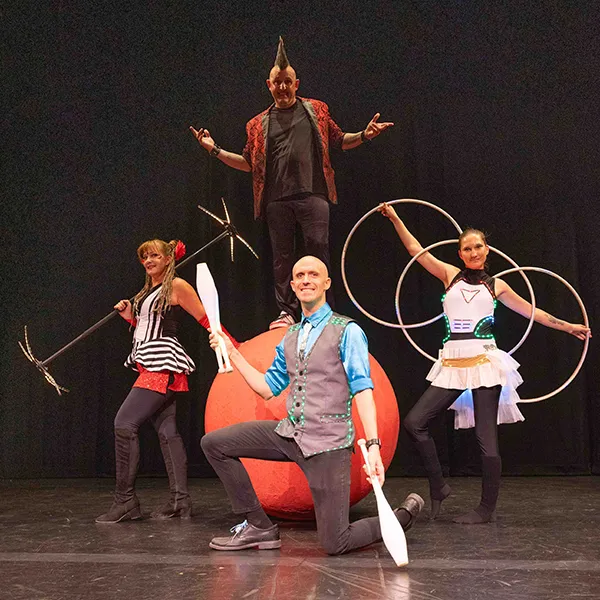 Circus Farm performers holding hoops and balancing on a bike