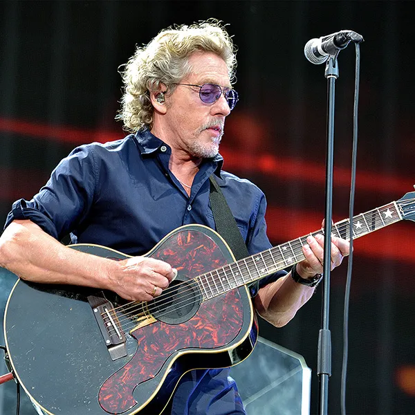 Roger Daltrey playing guitar on stage