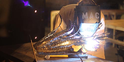 Student welding flower